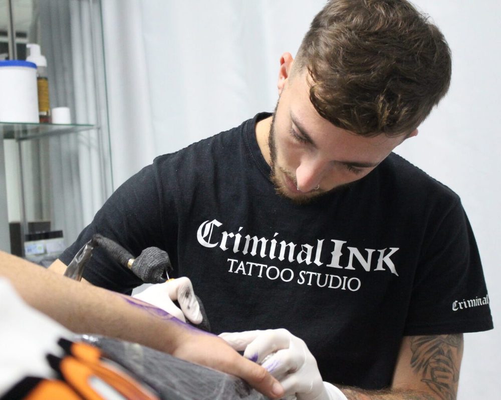 Tatuador de Criminal Ink trabajando en el estudio